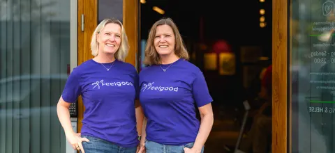 To ansatte i lilla Feelgood-t-skjorter ved inngangen til Feelgood Heggedal