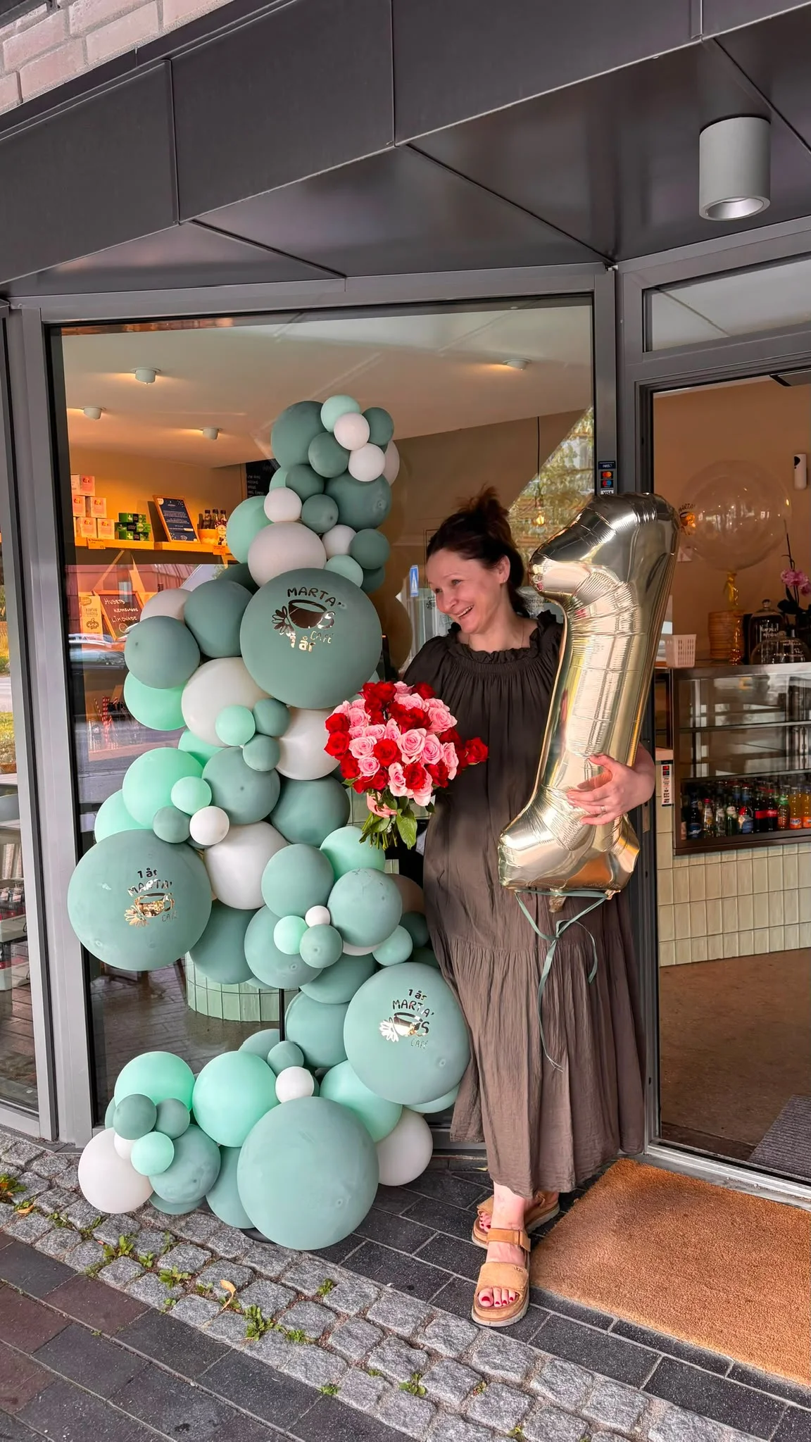 Feiring av ett års jubileum hos Marta’s Café, med ballongbue og en gullballong formet som tallet 1